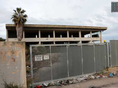 Troviamo lo scheletro di un edificio. Una targhetta informa che per entrare � necessario citofonare, ma in realt� il cancello � aperto e permette di avere accesso in un�area dominata da rifiuti, spazzatura e una palma morta. Era la sede della �Future Gate�, una societ� che costruiva e gestiva slot-machine 